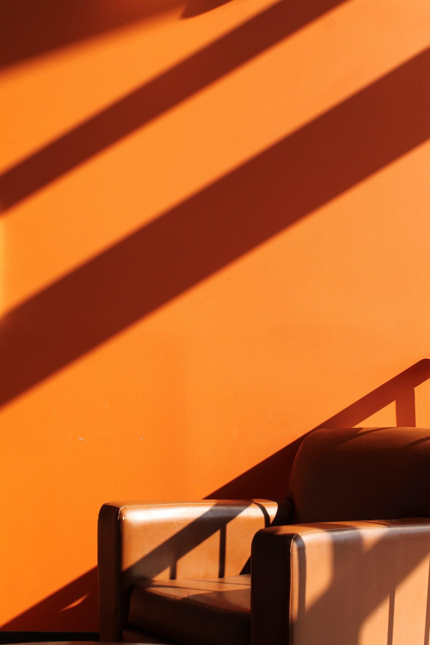 Orange Wand mit Schattenstreifen und Sessel