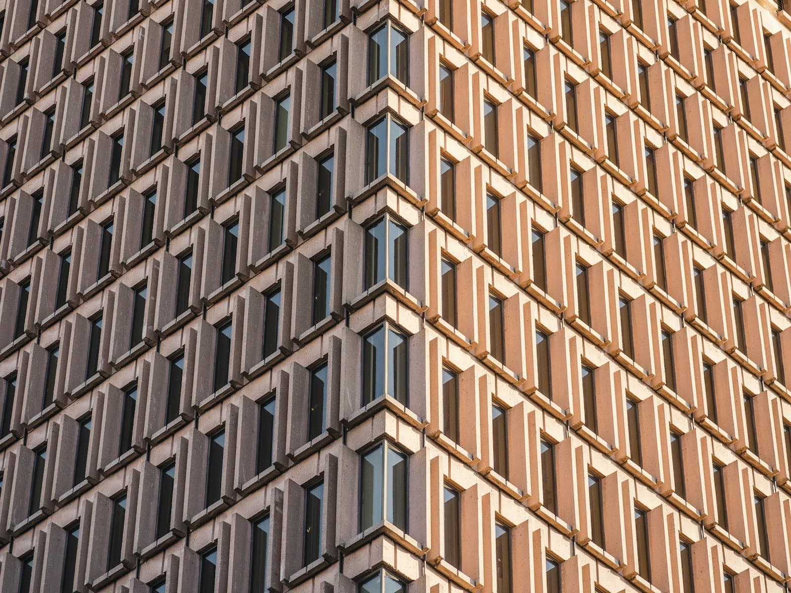 Sandsteinfassade mit Fensterraster im Abendlicht